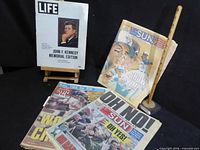 Overview showing Life JFK edition on easel plus three Sun tabloids