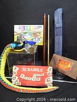 Group shot showing all items including games, pool cue, case, plush snake and medal