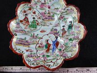 Top view of scalloped porcelain bowl showing full hand-painted figural landscape design