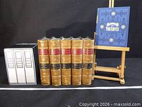 Full lot: five leather encyclopaedia volumes and one blue Tom Sawyer book