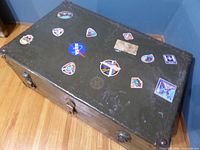 closed olive drab trunk with stickers on lid