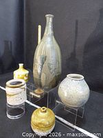 Group shot of all five stoneware pieces on risers
