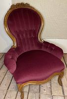 Full view of the carved wood chair showing upholstery and frame