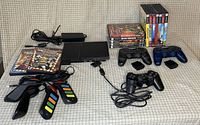 Overall lot showing console, controllers, memory cards and games