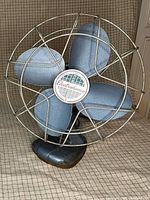 Front view of blue Electrohome fan with wire cage