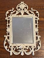 Full view of ornate cream cast iron mirror