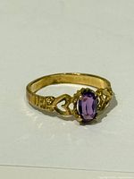 Top view of gold ring with amethyst and heart design