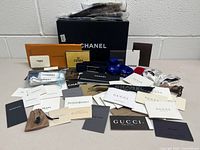 Wide shot of entire collection of designer tags, booklets, ribbons and Chanel box