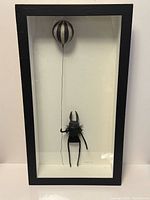 Full view of shadowbox with bunny sculpture and striped balloon