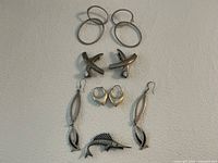 All items laid out: four earring pairs and swordfish brooch