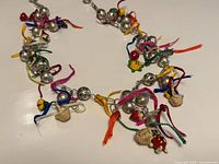 Full necklace laid flat showing charms, beads, ribbons