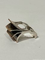 Oblique view showing stepped brutalist form and gold-tipped edges