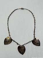 Full view of sterling silver necklace showing three leaf pendants and chain style