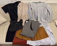 Group shot of all eight garments laid on sofa