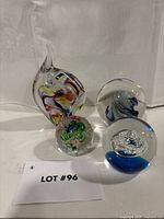 Group shot of all four glass paperweights