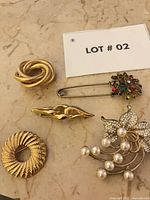 All five brooches laid out on marble surface