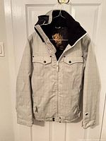 Front view of Billabong light grey plaid women’s snowboarding jacket on hanger