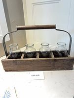Front view of wood carrier with four glass vases
