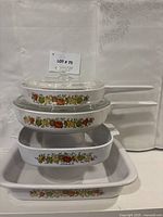 Stacked view of two handled saucepans, square casserole and rectangular pan with Spice of Life pattern