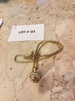 Full view of necklace and pendant on surface