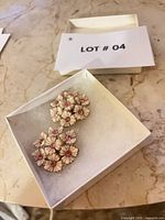 Top view of both daisy cluster earrings in box showing enamel petals and rhinestones