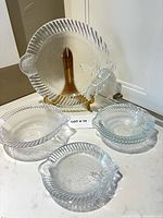 Front view of clear glass fish-shaped platter, three bowls/plates displayed