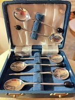 Open box showing six spoons, velvet lining