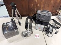 Entire lot laid out: camera, camcorder, bag, tripod, adapter, boxed card reader