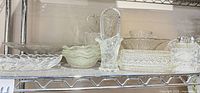 shelf of multiple clear pressed glass pieces
