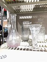 Four glass pieces on shelf: carafe, ribbed vase, bud vase, square decanter