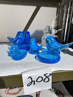 Group shot of five blue glass bluebird figurines on shelf