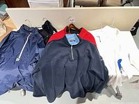 Group shot of six outerwear pieces on hangers