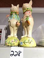 Front three-quarter view of both 20 in resin bunny figurines on floral mounds