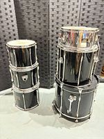 Two stacks of Pearl drum shells, five black lacquer, one steel