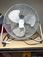Front view of Penguin metal floor fan showing guard, blades, stand and cord