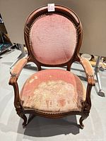 Front view showing full armchair, carved frame, pink upholstery