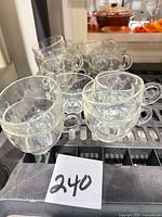 Group of clear glass snack cups stacked on rack, front view