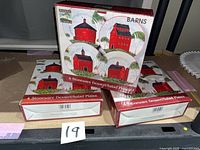 Front view of three unopened boxes showing plate design and quantity