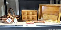 Group shot of wicker basket, wood cubby shelf, toy guitar, wood shadow-box shelf