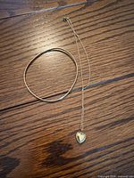 Necklace and bangle laid flat on wood surface