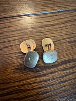 front and back of both cufflinks showing monogram and gold tone