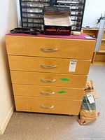 Front view showing five drawers and metal handles