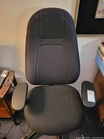 Full front view of black office chair showing seat, backrest, and armrests
