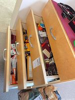 Three open drawers showing multimeter, tools and packaged components