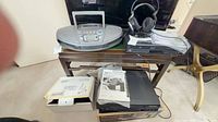 Overall lot view showing Panasonic boombox, Sony headphones, JVC DVD VCR combo, Panasonic VHS deck, cords