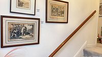 Two framed etchings on stairwell wall