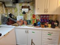 overview of countertop with pots, soil bags, bird feeder, edging roll, colored pots