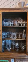 Cabinet showing full assortment of glassware on three shelves