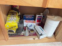 Cabinet interior with steel wool, acetone, line spool, wax tin and other supplies