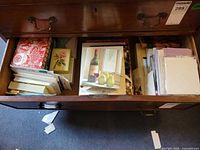 Open drawer showing stacks of assorted greeting cards and envelopes